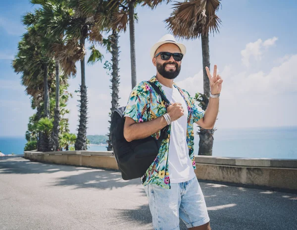 Hombre viajero joven en vacaciones de verano con hermosas palmeras y paisajes marinos en el fondo —  Fotos de Stock
