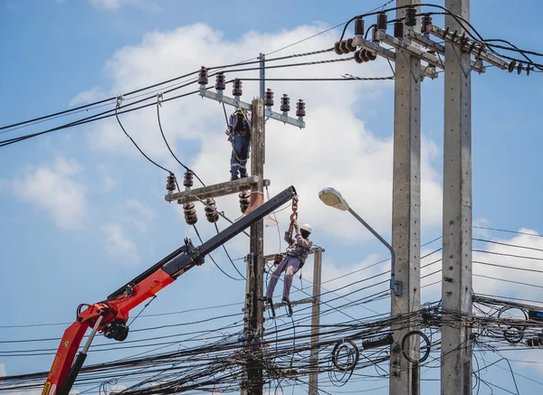 Electricians is repairing high voltage wires on electric power pole — Foto de Stock