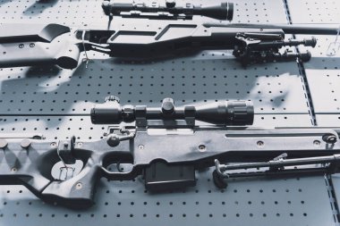 Duvarda tüfek ve tüfek koleksiyonu var.