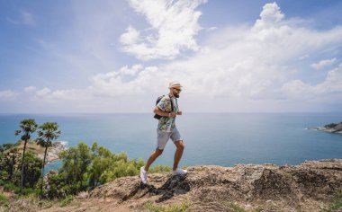 Yaz tatilindeki genç gezgin. Güzel dağları ve arka planda deniz manzaraları var.