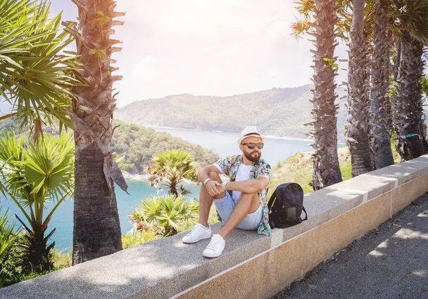 Jovem viajante homem em férias de verão com belas palmas e paisagens marinhas no fundo — Fotografia de Stock