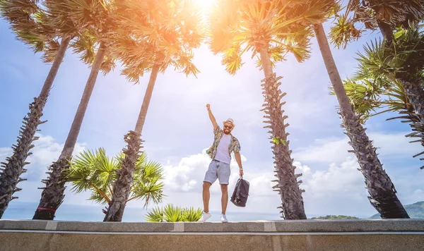 Young traveler man at summer holiday vacation with beautiful palms and seascapes at background — ストック写真