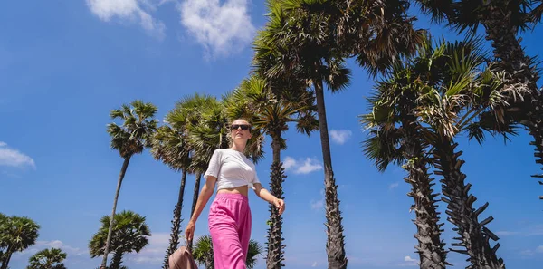 Young traveler woman at summer holiday vacation with beautiful palms and seascapes — Stock fotografie