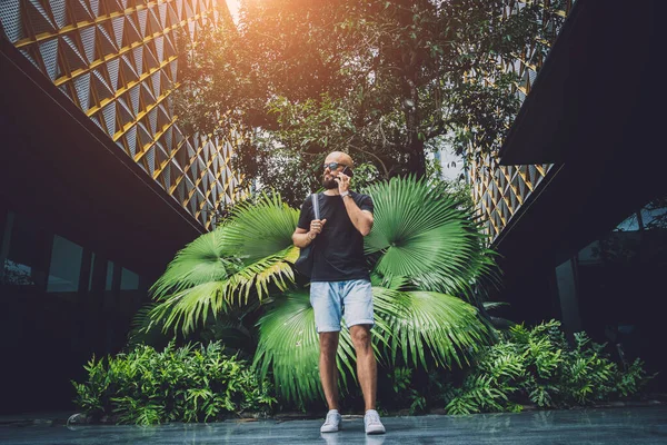 Portrait of a fashion young man at beautiful green leaves background in jungle — Stockfoto