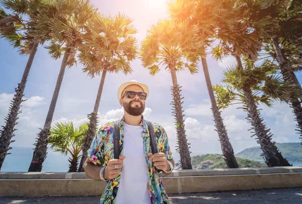 Young traveler man at summer holiday vacation with beautiful palms and seascapes at background —  Fotos de Stock