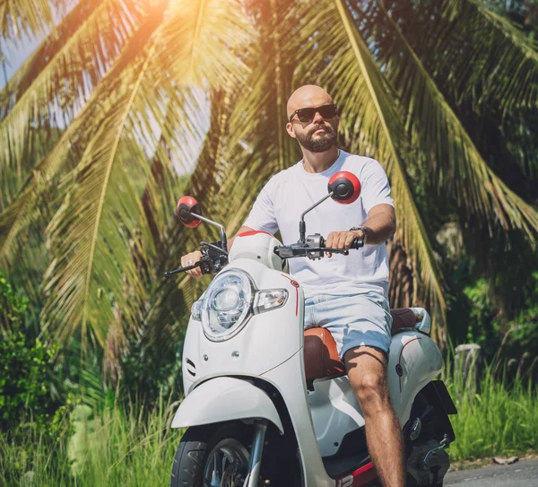 Stylish young man and his motorbike on the road in the jungle — Photo