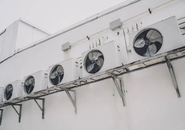 A row of split air conditioner condensers on a wall of a building — Foto de Stock
