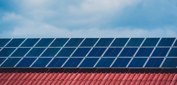 Sonnenkollektoren auf dem roten Dach eines zivilen Gebäudes — Stockfoto