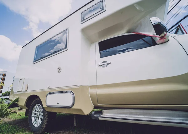 Travel camp trailer car with on the ground with grass