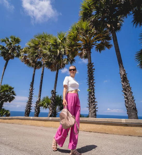 Yaz tatilindeki genç gezgin kadın güzel palmiyeler ve deniz manzaralarıyla