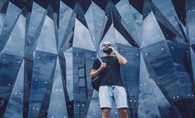 Modadan bir gencin portresi telefonda konuşuyor. Güzel, karanlık şehir arka planında.