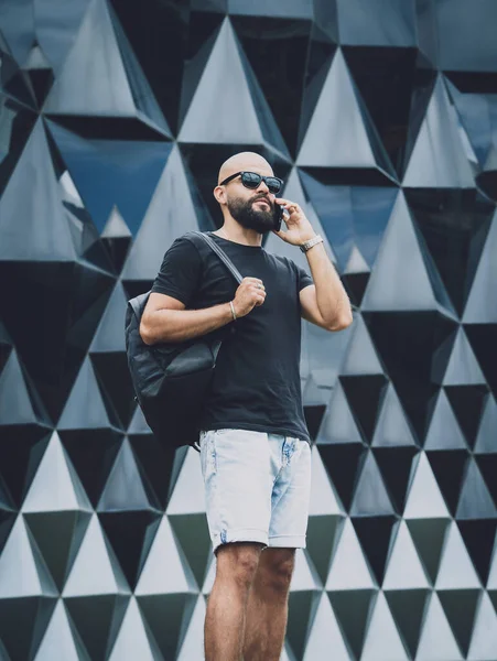 Portrait of a fashion young man talking by the phone at beautiful dark urban background — Stok fotoğraf