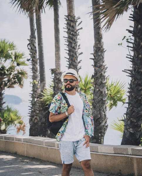 Young traveler man at summer holiday vacation with beautiful palms and seascapes at background — Fotografia de Stock