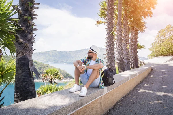 Young traveler man at summer holiday vacation with beautiful palms and seascapes at background —  Fotos de Stock