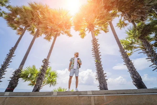 Yaz tatilinde arka planda güzel palmiyeler ve deniz manzaraları olan genç bir gezgin. — Stok fotoğraf