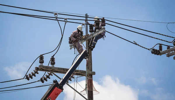 Electricians is repairing high voltage wires on electric power pole — Fotografia de Stock