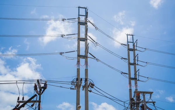 Elektrikçiler elektrik direğindeki yüksek voltajlı kabloları tamir ediyorlar. — Stok fotoğraf