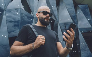 Modadan bir gencin portresi telefonda konuşuyor. Güzel, karanlık şehir arka planında.