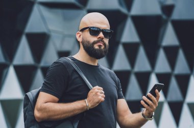 Modadan bir gencin portresi telefonda konuşuyor. Güzel, karanlık şehir arka planında.