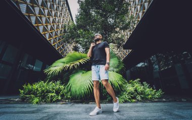 Ormanda yeşil yaprakları olan genç bir adamın portresi.