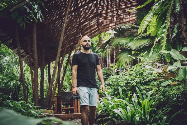 stock image Portrait of a fashion young man at beautiful green leaves background in jungle