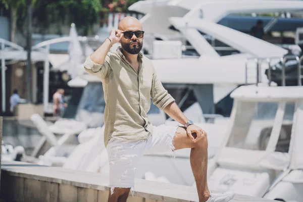 Portrait of a fashion young man posing at marina and yahts background —  Fotos de Stock