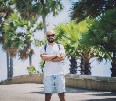 Yaz tatilinde arka planda güzel palmiyeler ve deniz manzaraları olan genç bir gezgin.