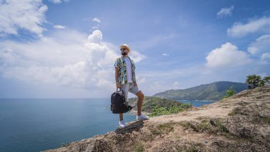 Yaz tatilindeki genç gezgin. Güzel dağları ve arka planda deniz manzaraları var.