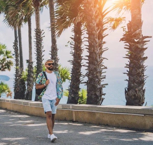 Hombre viajero joven en vacaciones de verano con hermosas palmeras y paisajes marinos en el fondo —  Fotos de Stock