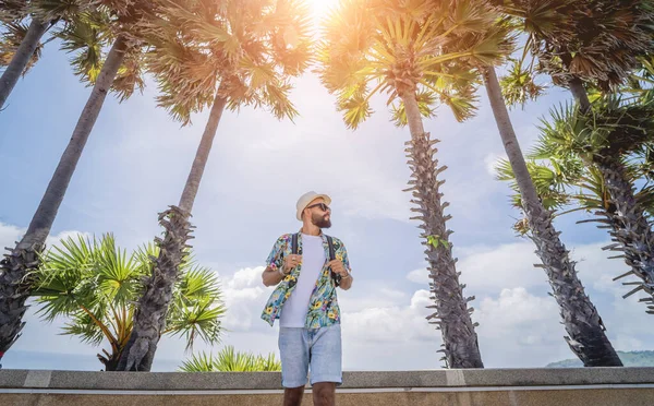 Young traveler man at summer holiday vacation with beautiful palms and seascapes at background — 스톡 사진