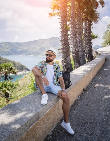 Jovem viajante homem em férias de verão com belas palmas e paisagens marinhas no fundo — Fotografia de Stock