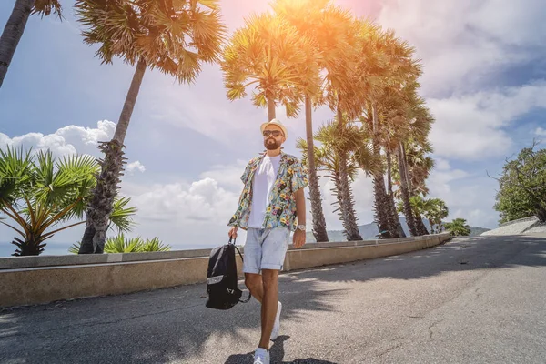 Hombre viajero joven en vacaciones de verano con hermosas palmeras y paisajes marinos en el fondo —  Fotos de Stock