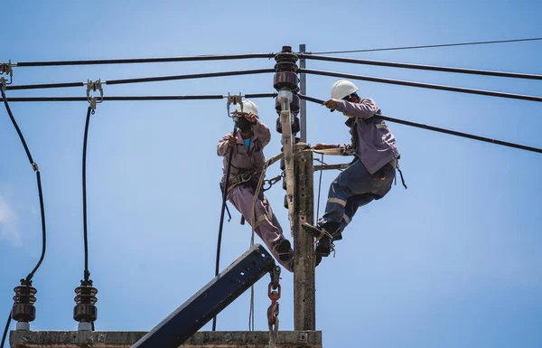 Electricians is repairing high voltage wires on electric power pole — Fotografia de Stock