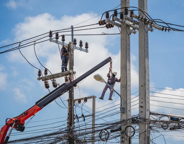 Elektrikçiler elektrik direğindeki yüksek voltajlı kabloları tamir ediyorlar. — Stok fotoğraf