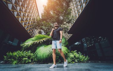 Ormanda yeşil yaprakları olan genç bir adamın portresi..