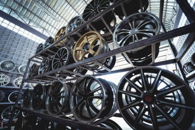 Bir dükkanda sıra sıra metal araba diskleri.