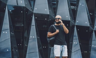 Modadan bir gencin portresi telefonda konuşuyor. Güzel, karanlık şehir arka planında..