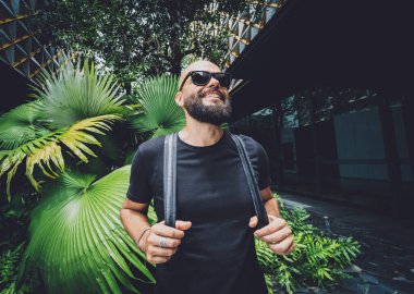 Ormanda yeşil yaprakları olan genç bir adamın portresi..