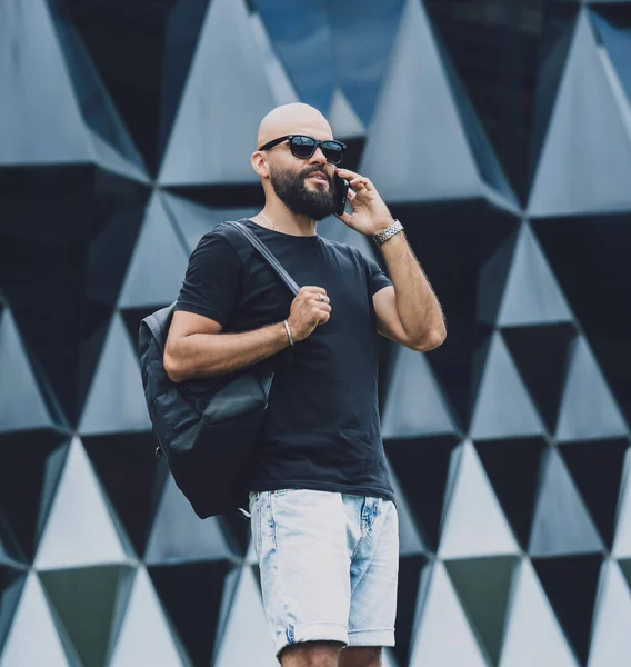 Modadan bir gencin portresi telefonda konuşuyor. Güzel, karanlık şehir arka planında..