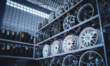 Bir dükkanda sıra sıra metal araba diskleri.