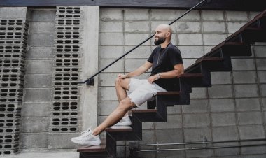 Şehrin sokaklarındaki merdivenlerde tişörtlü ve şortlu genç bir adam..