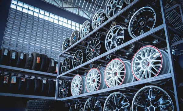 Bir dükkanda sıra sıra metal araba diskleri.