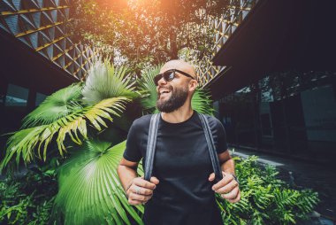 Ormanda yeşil yaprakları olan genç bir adamın portresi..