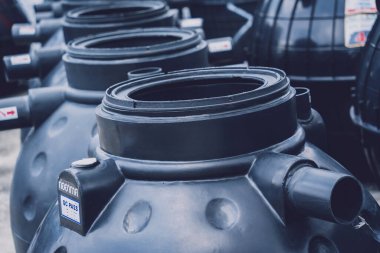 Üretici fabrikasındaki siyah plastik su deposu..