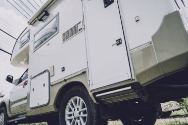 Travel camp trailer car with on the ground with grass.