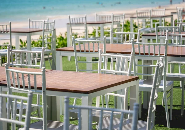 Large beach cafe with tables and chairs placed at the sea waterfront.