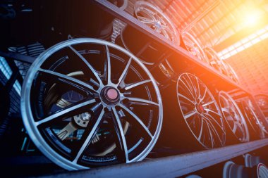 Bir dükkanda sıra sıra metal araba diskleri.