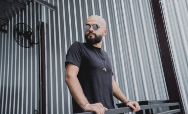 Şehrin sokaklarındaki merdivenlerde tişörtlü ve şortlu genç bir adam..