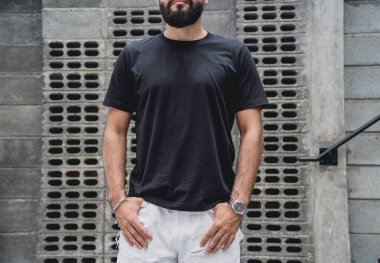 Şehrin sokaklarında tişörtlü ve şortlu genç bir adam..