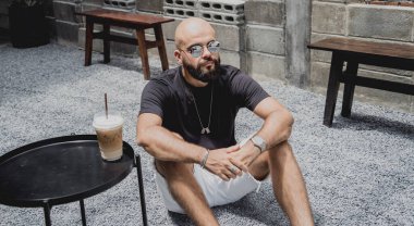 Modern şehir kafesinde tişört ve şort giyen genç bir adam..